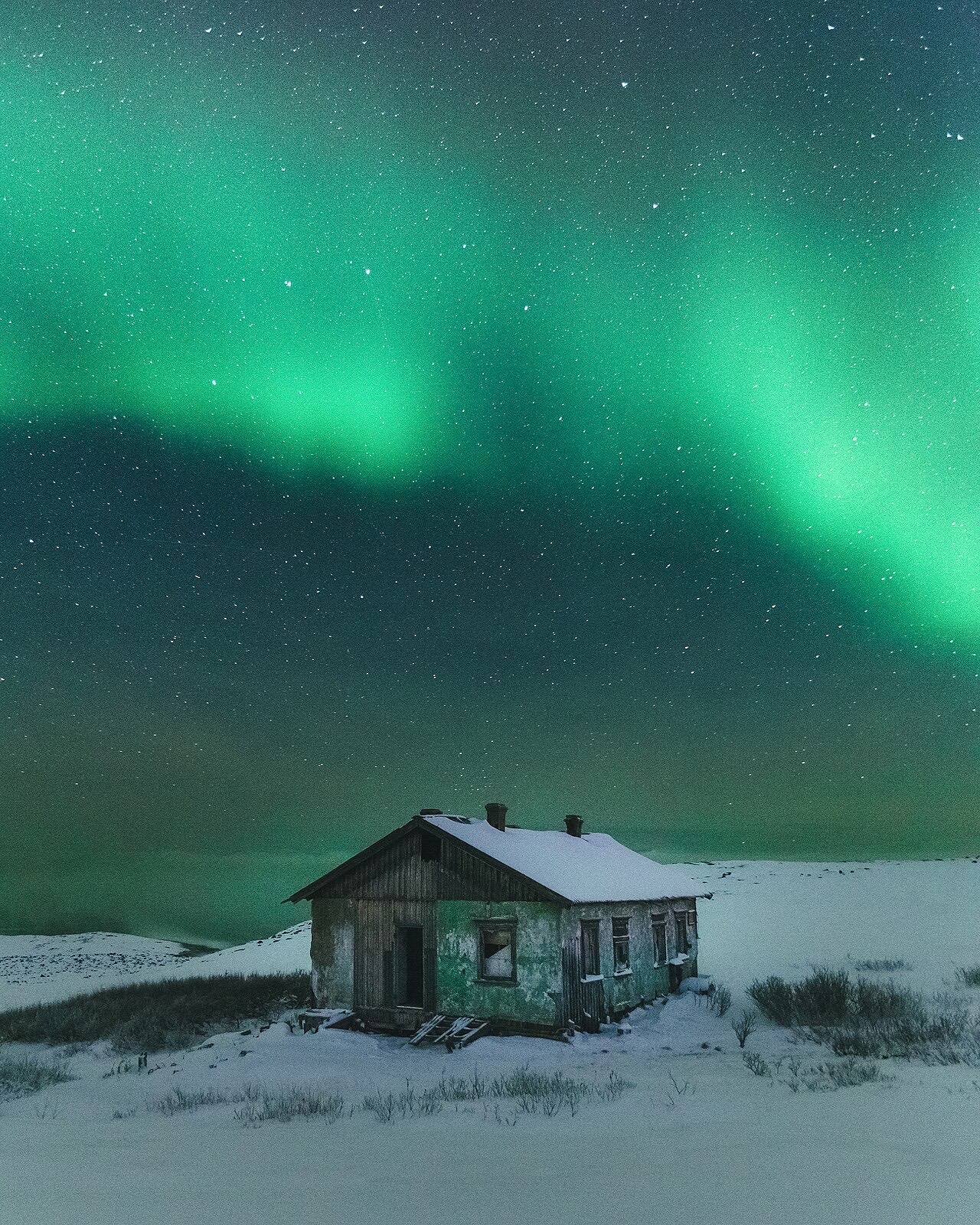Northern lights over an abandoned building of weather station in Teriberka.